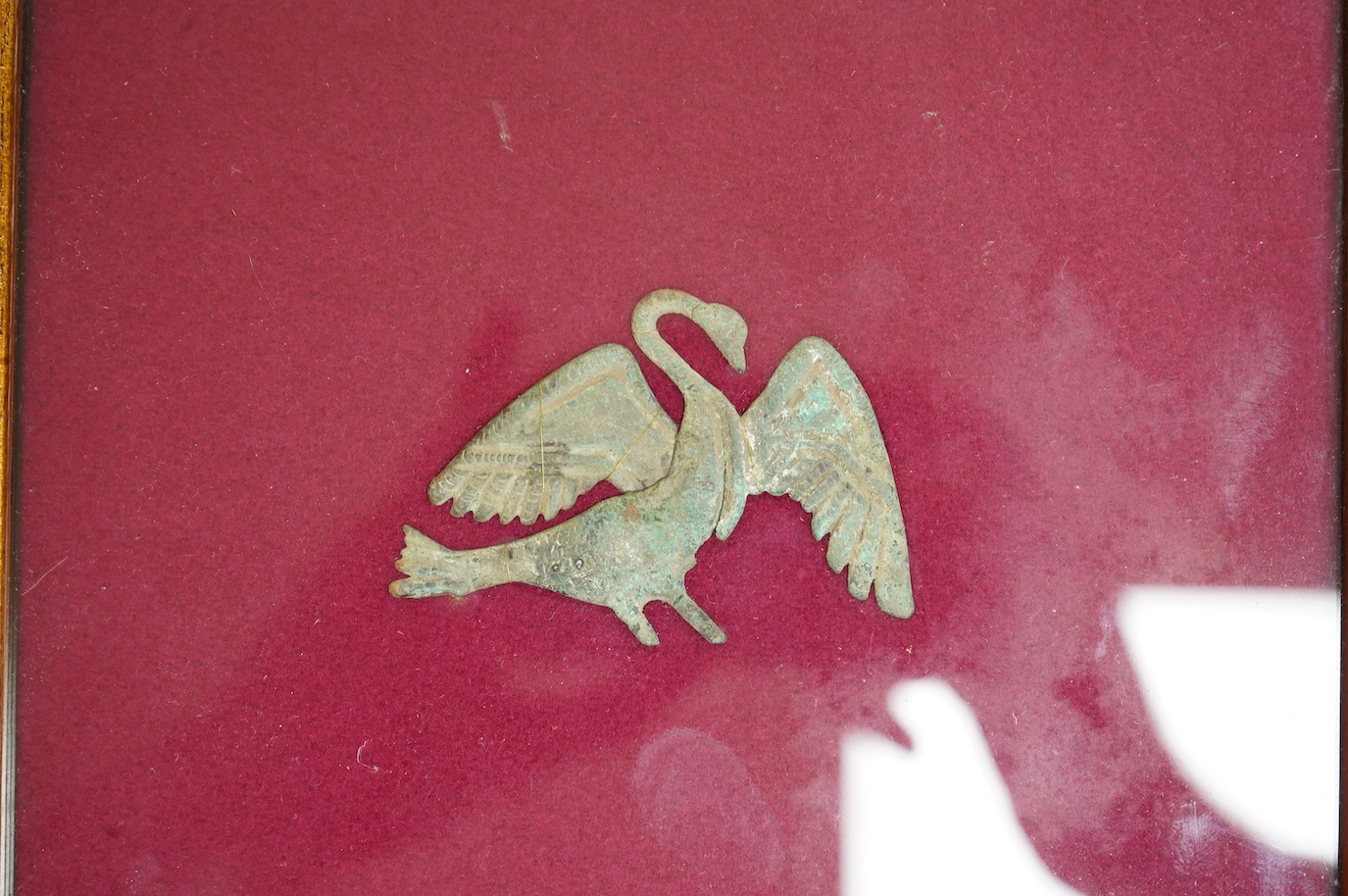 A Roman bronze badge, a medieval pewter badge and silver badges in the form of Sardinia emblems all framed., Swan badge 6cm wide, not including mount or frame. (Requires provenance)